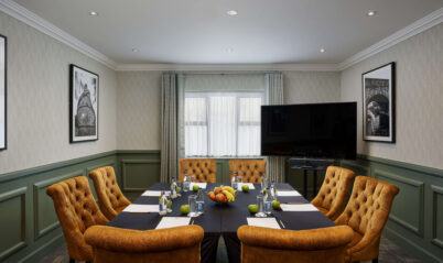 Cosy meeting room with plush seating and table set for conference at Springfield Hotel.