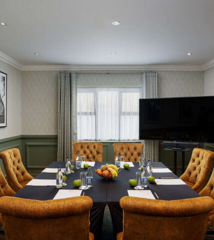 Cosy meeting room with plush seating and table set for conference at Springfield Hotel.