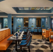 Hotel dining area with blue and orange decor, tables set for a family meal.