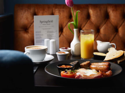 Family enjoying hearty breakfast at Springfield Hotel with fresh juice and coffee.
