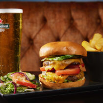 A delicious cheeseburger with chips and a glass of beer, perfect for family dining at Springfield Hotel.