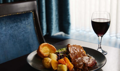 Elegant dining setting with roast dinner and wine in Springfield Hotel.