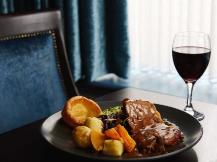 Elegant dining setting with roast dinner and wine in Springfield Hotel.