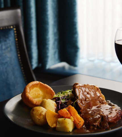 Elegant dining setting with roast dinner and wine in Springfield Hotel.