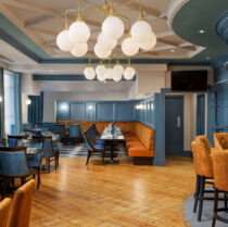 Chic hotel dining area with families gathered under modern chandeliers.
