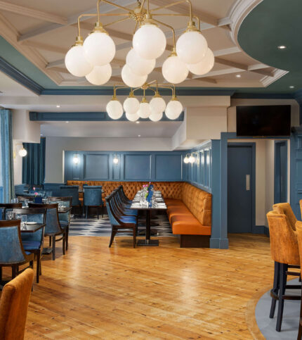 Chic hotel dining area with families gathered under modern chandeliers.