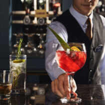 Bartender serving cocktails to a couple at Springfield Hotel bar.