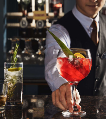 Bartender serving cocktails to a couple at Springfield Hotel bar.