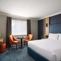 Cosy hotel room with king-size bed and seating area for relaxation.