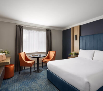 Cosy hotel room with king-size bed and seating area for relaxation.