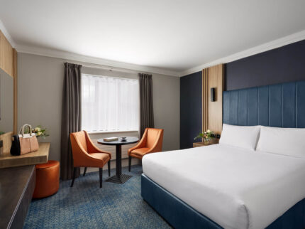 Cosy hotel room with king-size bed and seating area for relaxation.