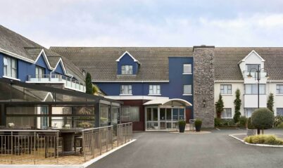 Family enjoys Springfield Hotel entrance, blue facade with welcoming outdoor seating area.