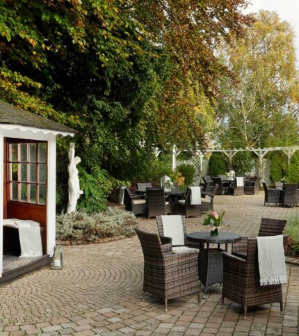 Family enjoying outdoor dining in a lush garden at Springfield Hotel.