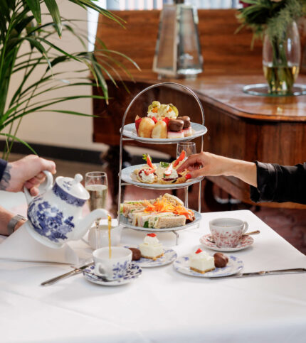 Family enjoying afternoon tea with pastries at Springfield Hotel, elegant setting.