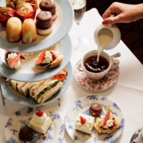 A family enjoys afternoon tea with a three-tiered stand of pastries and sandwiches at Springfield Hotel.