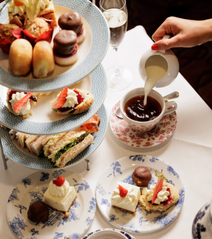 A family enjoys afternoon tea with a three-tiered stand of pastries and sandwiches at Springfield Hotel.