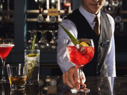 Bartender serving colourful cocktails to guests at Springfield Hotel bar.