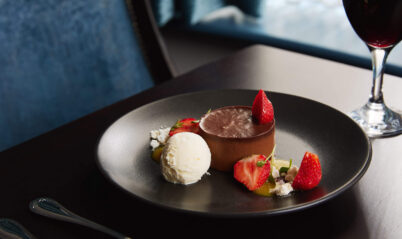 Elegant dessert with chocolate mousse and strawberries in a cosy Springfield Hotel setting.