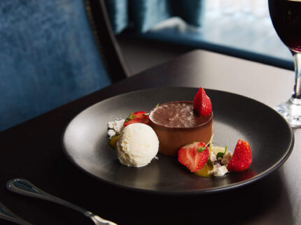 Elegant dessert with chocolate mousse and strawberries in a cosy Springfield Hotel setting.
