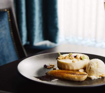 Elegant dessert and wine in a cosy hotel dining setting.