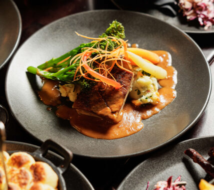 Family dining with gourmet beef dish and vegetables at Springfield Hotel restaurant.