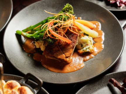 Family dining with gourmet beef dish and vegetables at Springfield Hotel restaurant.