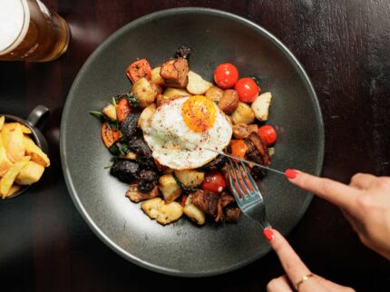 Delicious gourmet breakfast with fried egg, roasted vegetables, and beer at Springfield Hotel.