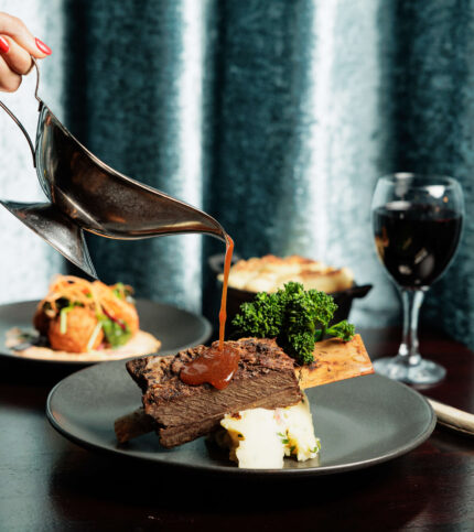 Gourmet meal at Springfield Hotel with red wine and elegant plating.