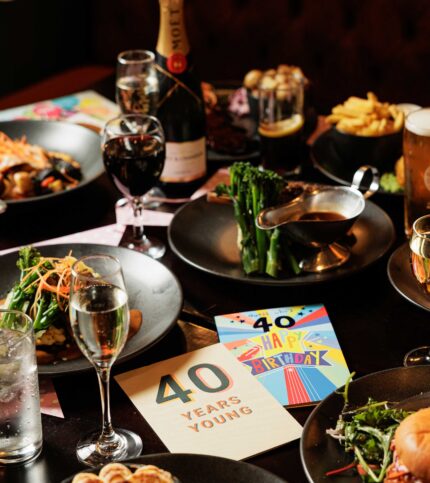 Elegant dinner table set for birthday celebration at Springfield Hotel with champagne and gourmet dishes.