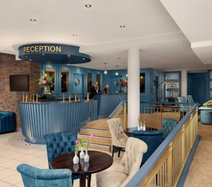 A welcoming hotel reception area with a family checking in, featuring elegant blue decor.