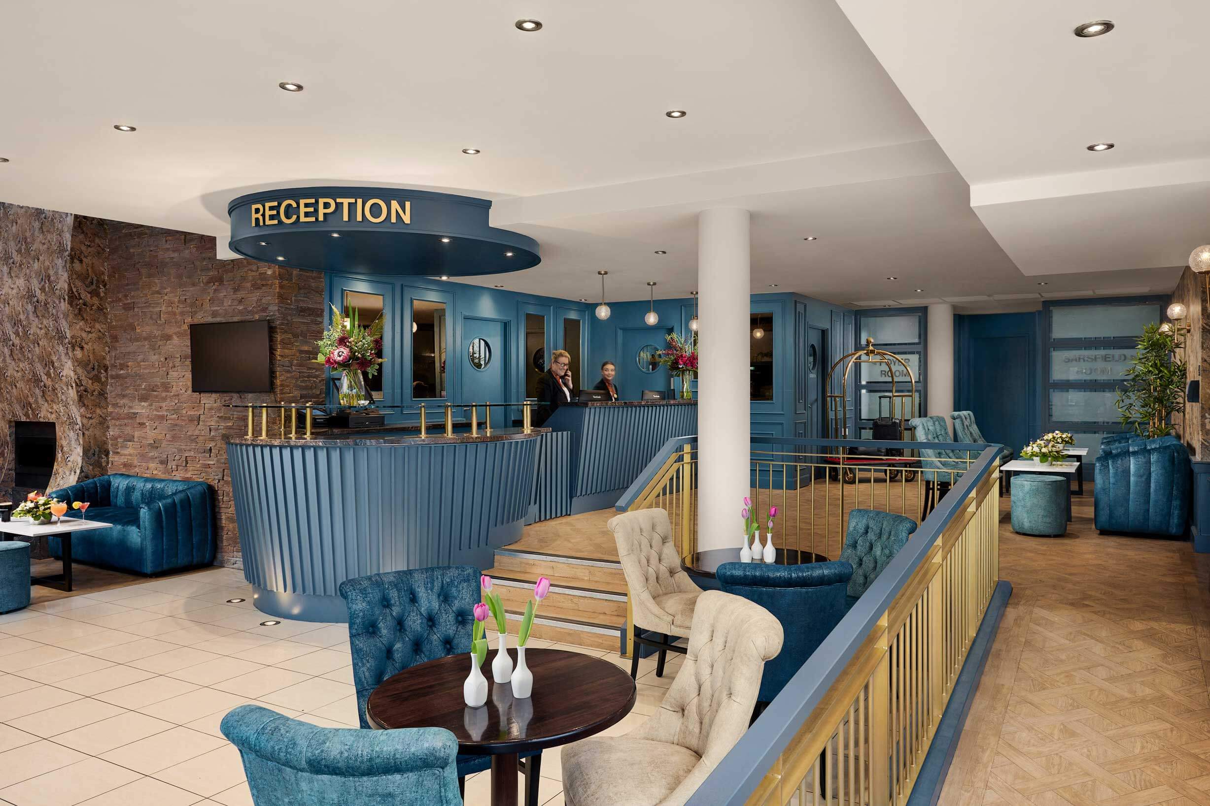 A welcoming hotel reception area with a family checking in, featuring elegant blue decor.