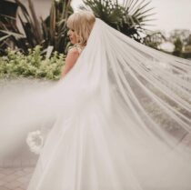 Bride in flowing white gown with long veil at Springfield Hotel garden.