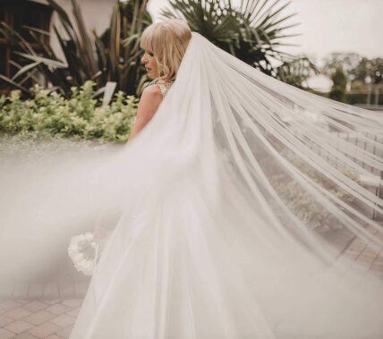 Bride in flowing white gown with long veil at Springfield Hotel garden.