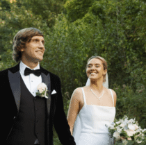 A couple joyfully strolls through lush gardens at Springfield Hotel on a sunny day.