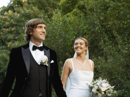 A couple joyfully strolls through lush gardens at Springfield Hotel on a sunny day.
