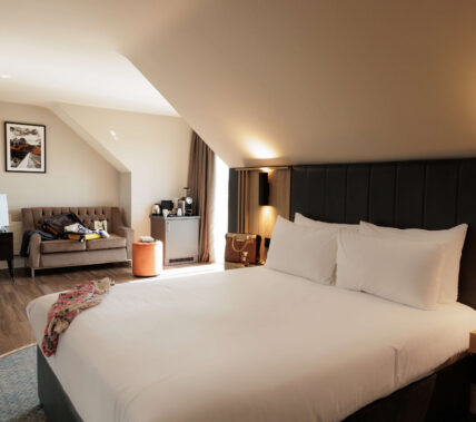 Cosy hotel room with king-sized bed and welcoming seating area for families or couples.