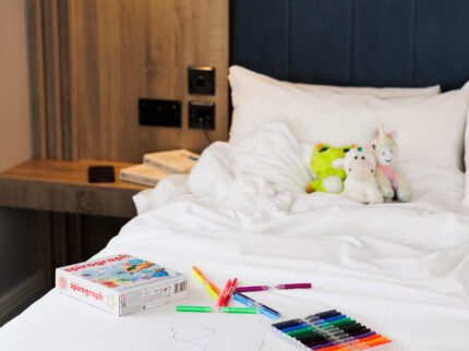Cosy Springfield Hotel room with plush toys and art supplies on bed.