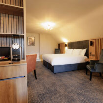 Spacious Springfield Hotel room with a large bed and cosy seating area, offering a warm and inviting atmosphere.