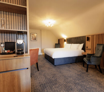 Spacious Springfield Hotel room with a large bed and cosy seating area, offering a warm and inviting atmosphere.