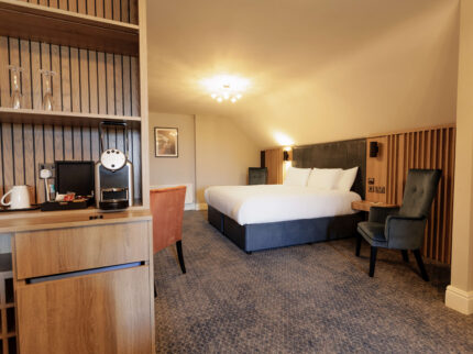 Spacious Springfield Hotel room with a large bed and cosy seating area, offering a warm and inviting atmosphere.