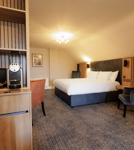 Spacious Springfield Hotel room with a large bed and cosy seating area, offering a warm and inviting atmosphere.