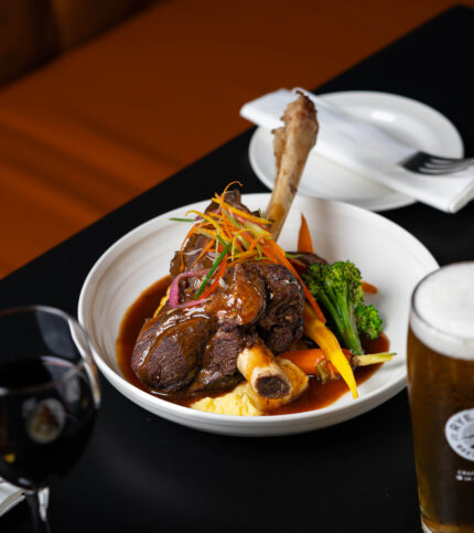 Savoury lamb shank with vegetables, lush dining at Springfield Hotel restaurant.