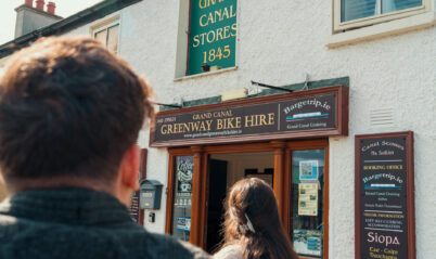 A couple approaches a charming, historic bike rental shop in Springfield for an adventure.