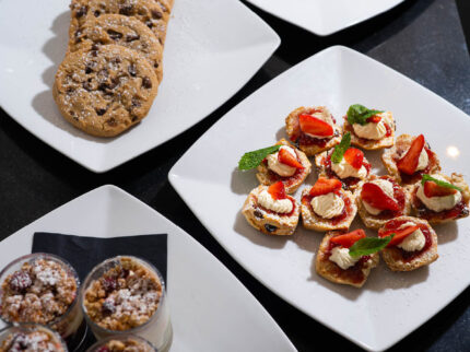 Uma variedade de sobremesas e petiscos elegantes, incluindo biscoitos, frutas e canapés, estão em exposição no Hotel Springfield.