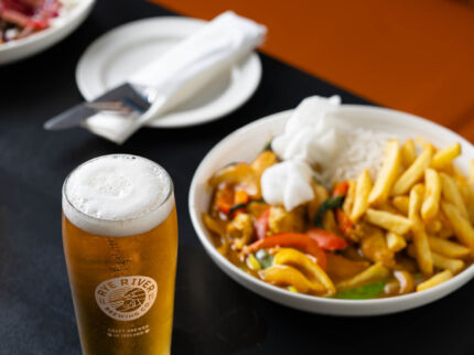 Deliciosa comida de curry con patatas fritas y una cerveza espumosa en el restaurante del Hotel Springfield.